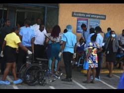 Persons rush to the Kingston Public Hospital on Monday after the magnitude 5.6 earthquake rocked sections of Jamaica.