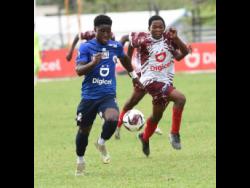 Jamaica College’s (JC) Jamoy Dennis (left) outruns Eltham High’s Kevin Clarke (right) during their ISSA/Digicel Manning Cup schoolboy football match yesterday at Ashenheim Stadium. JC won 3-1 to advance to the quarter-finals 6-1 on aggregate.