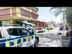 Police cordon the area where two men were shot at their business establishment on Princess Street in downtown Kingston yesterday. 