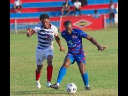 Portmore United’s Alex Marshall tries to win the ball from Dunbeholden’s Fabian McCarthy during their Jamaica Premier League match at Ferdie Neita Park yesterday, which Portmore won 2-0.