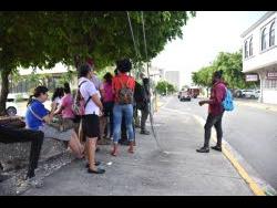 The work day came to a halt for businesses inside the New Kingston Business Centre yesterday after a bomb threat was reported about 10 a.m. Employees of the various entities wait for security personnel to complete a search.