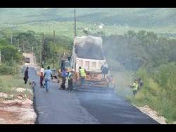 Workmen repair a section of roadway as part of the ongoing Essex Valley Agricultural Development Project in St Elizabeth.