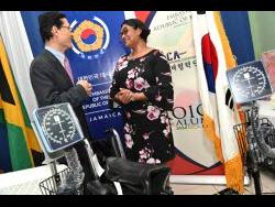 Kim Jinwook (left), chargé d’affaires in the Embassy of the Republic of Korea, chats with Major (ret’d) Dr Susan Wright, assistant regional technical director of the South East Regional Health Authority, after the handover of medical supplies to the Kingston Public Hospital on Tuesday.