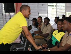 Minister of Agriculture, Fisheries and Mining, Floyd Green (left), interacts with youngsters during the national ‘Eat Jamaica Day’ ceremony at the College of Agriculture, Science and Education in Portland recently.
