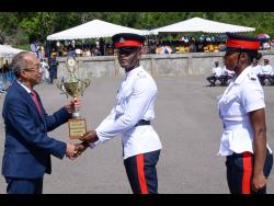 Minister of National Security Dr Horace Chang (left) presents Constable Kenneil Datadeen with the trophy for obtaining the highest marks, during the passing-out parade for 290 new Jamaica Constabulary Force constables. The event was held on Wednesday at the National Police College of Jamaica in Twickenham Park, St Catherine. Looking on is Woman Constable Zennesah Francis, who was the joint recipient for attaining the highest marks.