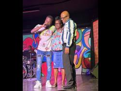Sajay Deacon (left) shares a special moment on stage with his parents Noreen and Samuel Deacon. 