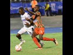 Cavalier’s Jalmarco Calvin (left) battles for the ball with Robinhood’s Allierio Belfor during their Concacaf Caribbean Cup second-leg football final at the National Stadium last night. Robinhood won 2-0 to take the tie 3-0 on aggregate.