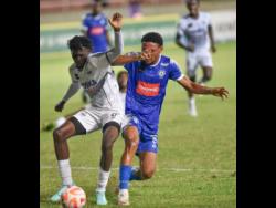Cavalier’s Jerome McLeary (left) comes under pressure from Mount Pleasant Football Academy’s Odane Murray during their Wray and Nephew Jamaica Premier League match at Sabina Park last night. Cavalier won2-1.