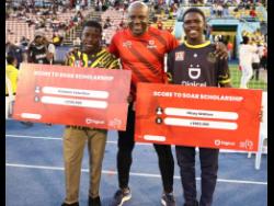 Haile Selassie High’s Kishawn Valentine (left) and Nicoy Valentine (right) of Kingston Technical High hold symbolic cheques presented to them by Digicel’s Head of Communications and Corporate Affairs, Elon Parkinson.