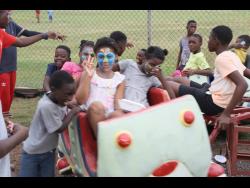 Children from Boys’ Town enjoy a ride during the Christmas treat, held on Sunday at the Collie Smith Drive Sporting Complex in the South St Andrew community. 