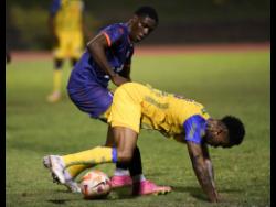Harbour View’s Andre Fagan (right) is bundled over by Lime Hall’s Tyreek McAlla during their Jamaica Premier League match at Stadium East yesterday. Harbour View won 3-0.