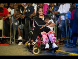 Pauline Espeut watches the performances with four-year-old Josh asleep on her lap.