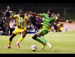 Donovan Clarke (right) of Vere United tackles Javane Bryan of Waterhouse during a Jamaica Premier League match at the Stadium East field on November 20, 2023. Bryan scored a hat-trick to lead  Waterhouse to a  4-1 victory. 