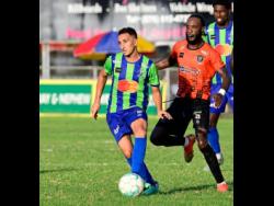 Montego Bay’s Jean Claudio Rios Ferreira (left) is chased by Tivoli Gardens’ Keno Simpson during their Jamaica Premier League match at Anthony Spaulding Sports Complex yesterday. Montego Bay won 2-1.