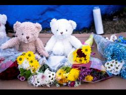 Bears and flowers sit in front of a rock painted to memorialise Perry High School shooting victim Ahmir Jolliff at the school on Saturday in Perry, Iowa. Jolliff was one of eight victims in the shooting. Seven others received wounds or injuries of varying degrees, the Iowa Department of Public Safety said.