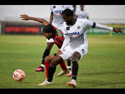 Arnett Gardens’  Jamone Shepherd (left) is tackled strongly by Cavalier’s Gadail Irving during Sunday’s rescheduled Jamaica Premier League match at Sabina Park. Cavalier won 3-0.