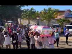 Mourners carry the coffin bearing the remains of Errol McDonald.