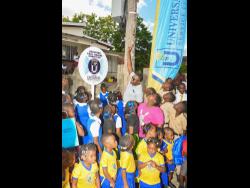 Minister with responsibility for Information and Member of Parliament for Clarendon North Central, Robert Morgan (centre, back row), celebrates the launch of the Universal Service Fund’s free, secured Wi-Fi service in Beckford Kraal, Clarendon, with students from the community. The Wi-Fi was unveiled last week.