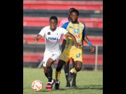 Cavalier’s Dwayne Atkinson (left) is chased by Harbour View’s Rohan Brown in their Jamaica Premier League fixture at Anthony Spaulding Sports Complex yesterday. Cavalier won 1-0.