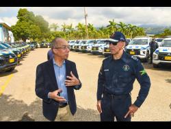 National Security Minister Dr Horace Chang (left) in discussion with Commissioner of Police Major General Antony Anderson at the handover of  several L-200 pickup trucks last Thursday at the Office of the Commissioner of Police in Kingston. 