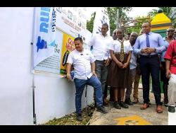 Minister with responsibility for water, Matthew Samuda (left), turns on a pipe, which is connected to the newly commissioned Cascade water supply in Hanover Eastern. 