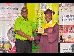Kimberly Simpson collects her award for Most Outstanding Female from junior agriculture minister Franklyn Witter at the Caribbean Christian Centre for the Deaf in Knockpatrick, Manchester, last Friday.