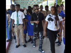 Nigy Boy is surrounded by students at the Salvation Army School for the Blind and Visually Impaired, his alma mater, located on Mannings Hill Road in St Andrew. 
