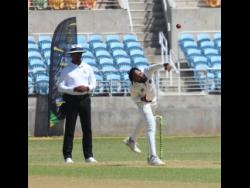 Umpire Gregory Brathwaite (left) watches as Barbados Pride’s Jomel Warrican bowls against the Jamaica Scorpions at Sabina Park yesterday. Warrican snared five wickets.