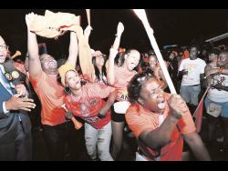Supporters of Jesse Clarke celebrate at the People’s National Party’s headquarters in St Andrew last night after he defeated Kari Douglas of the Jamaica Labour Party. Douglas, the incumbent, switched parties in 2020.