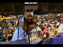 Edwin Allen's Tonyan Beckford (right) gets a hug from her mother Deneka Smith after she won the Open girls' 400 metres hurdles at the ISSA/GraceKennedy Boys and Girls' Athletics Championships at the National Stadium tonight. Beckford ran 56.70 to secure the victory.
