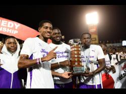 Kingston College members celebrate with the Mortimer Geddes Trophy after their overall victory at the ISSA/GraceKennedy Boys and Girls' Athletics Championships at the National Stadium tonight.