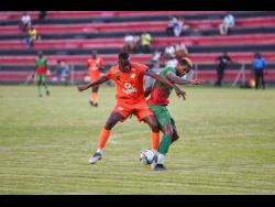 Lime Hall Academy’s Damani Sewell (left) and Humble Lion’s Andre Clennon battle for possession of the ball during their Jamaica Premier League football match at the Anthony Spaulding Sports Complex last night. Humble Lion won 6-0.