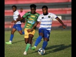 Treasure Beach’s Xavier Lamont (left) pressures Vere United’s Nathaniel Howe during their Jamaica Premier League encounter at the Anthony Spaulding Sports Complex yesterday. The match drew 0-0.