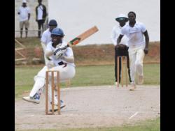 Manchester High’s Pajay Nelson (centre) grimaces in pain after being hit by a delivery from May Day High’s Reon Edwards on the first day of the ISSA/GK Insurance Headley Cup schoolboy cricket final at Manchester High School on Wednesday. Watching the action is Nelson’s teammate Rhevon Morgan (left).