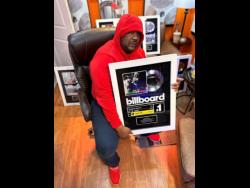 Producer Kemar McGregor holds one of his Billboard plaques.