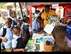 Kerry Ann McLean, forest technician at the Forestry Department, interacts with students at the St Ann 4-H Clubs Parish Achievement Day and Expo 2024 at the Brown’s Town Primary School. 