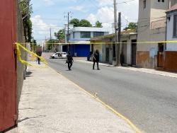 Police cordon off the area where men reportedly engaged the police in a shootout early yesterday in downtown Kingston.