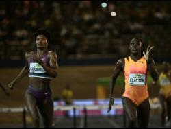 Jamaica's Rushell Clayton (right) wins the women's 400 metres hurdles ahead of United States of America's Ann Cockrell at the Jamaica Athletics Invitational at the National Stadium tonight.