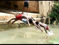 Photos by Ian Allen/Photographer
From left: Nickoy McKnight, Romaine Williams and Jordane Russell dive into the cool waters in Springvale, near Bog Walk, St Catherine.
