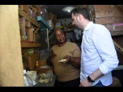 Nadine Leslie (left) business operator in Maverley, St Andrew, sells a piece of salt fish to Orjan Olsen, a Norway seafood representative who visited the island last week.