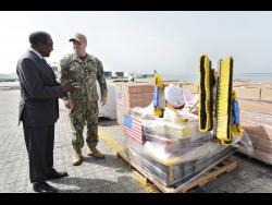 United States Ambassador to Jamaica, Nick Perry (left), and Lt Cmdr Zachary Smith, mission commander, Continuing Promise 2024, check some of the relief supplies.