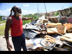 Errol Thomas shows the remains of his workshop which was destroyed by Hurricane Beryl. 