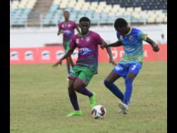 Ashley Anguin/Photographer 
Kaheel Campbell (left) of William Knibb Memorial High School competes with Denton Livingston of Cedric Titus High during their Zone D football match in the ISSA/WATA daCosta Cup competition at the Trelawny Multi-Purpose Stadium on Saturday. William Knibb won 3-0.