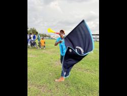 Ronaldo ‘Pegleg’ Webley, a mascot for 20 years, blows his vuvuzela and waves The Manning’s School flag during their WATA ISSA daCosta Cup football match against Godfrey Stewart at The Manning’s School on Saturday.