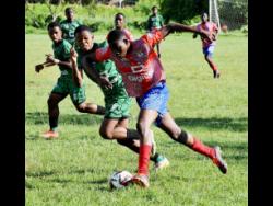 Noel Archibald (right) of Camperdown High dribbles while under pressure from Calabar High’s Sheldon Pusey and Dwayne White (left) during their ISSA Manning Cup football match on Friday. Calabar High won 2-0.