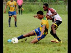 Rusea’s High School’s Wayne Brown (left) loses his footing under the challenge of Anchovy High School’s Jaquan Bent during their ISSA/WATA daCosta Cup Zone B football encounter at Collin Miller Sports Complex in Lucea, Hanover yesterday. Rusea’s High won 5-1. 