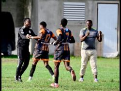 Kaquimmarie McKoy (second left) of Tivoli Gardens High School celebrates scoring a goal against Wolmer’s Boys’ School with assistant coach Courtney Dowdie (left), head coach Christopher Nicholas (right) and teammate Daquan Duhaney during the ISSA Manning Cup football fixture at Tivoli Gardens High School in Kingston on Thursday. Tivoli Gardens High won 4-2.