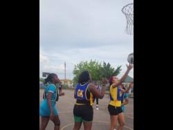 Goal defence Chenika Jones  of Clear  Express Shipping collects a  rebound as teammate, goalkeeper Suthania Scott, looks on during semi- final action in the Scrappy Nevers and Randy Williams  Netball Rally at the Longsville Park Community Centre in Clarendon on Monday.