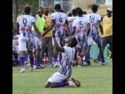 Members of Kingston College’s Manning Cup football team celebrate after scoring against Wolmer’s Boys during their round of 16 match at the  Stadium East field yesterday.