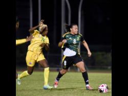 Credit: Ashley Anguin South Africa’s Nomvula Kgoale (left) tries to catch up with Jamaica’s Drew Spence during the international friendly football match at the Montego Bay Sports Complex on Friday. The Reggae Girlz won 3-0.